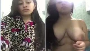 Watch as a stunning girl flaunts her big breasts in a seductive manner