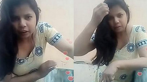 Watch a bhabi with visible cleavage bend and tease in a live video